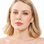 Model wearing Oplenza Signature Longwear Matte Lipstick in 02 Peche, showing nude peach matte lips.