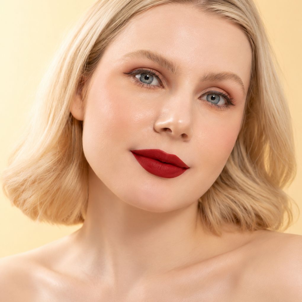 Model wearing Oplenza 12 Bordeaux red matte lipstick, showing the colour on fair skin.