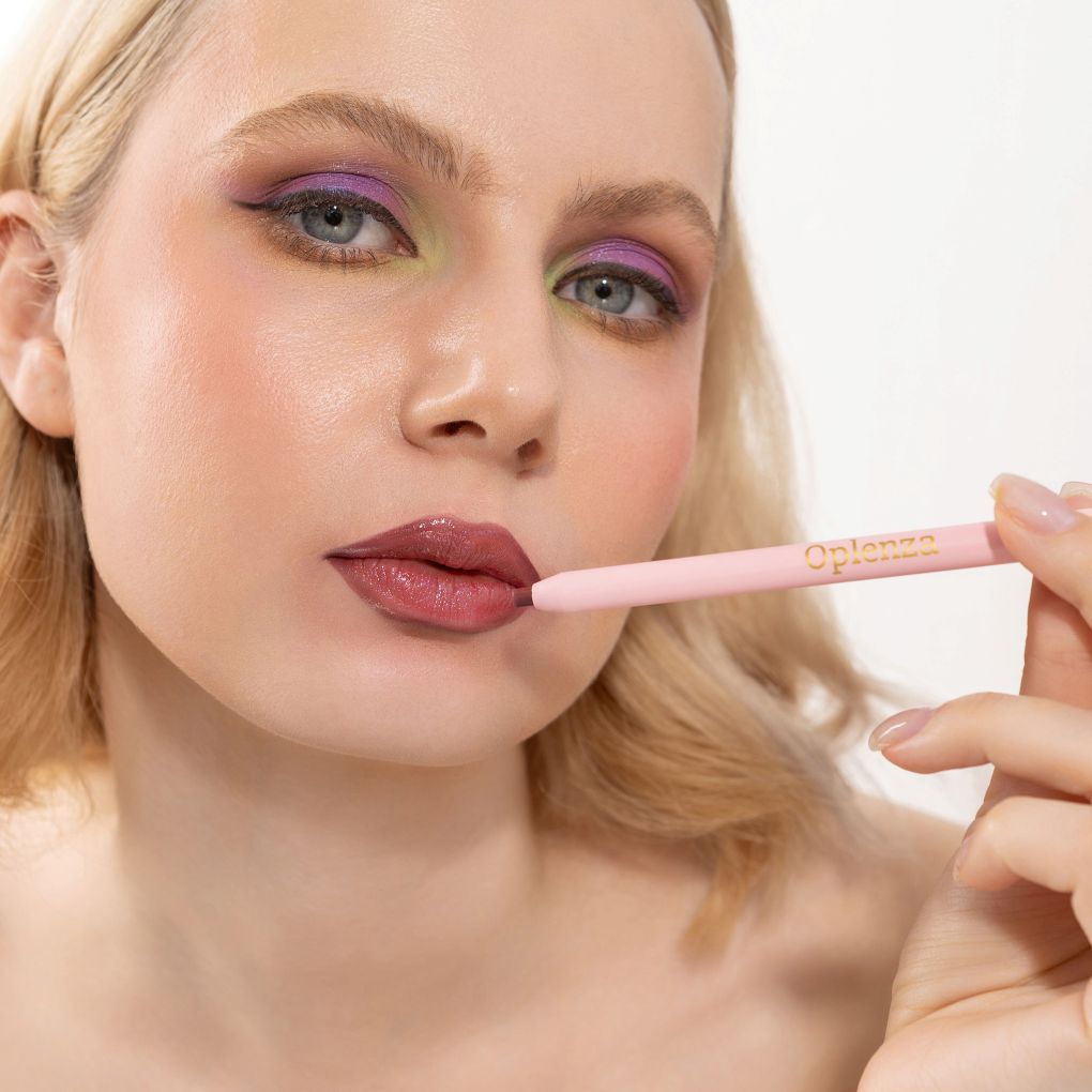 An elegant woman wearing and showcasing the vegan, luxury and cruelty free oplenza Define & Refine Lip Liner in the color 23 Berry Bold