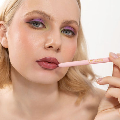 An elegant woman wearing and showcasing the vegan, luxury and cruelty free oplenza Define & Refine Lip Liner in the color Berry Bold