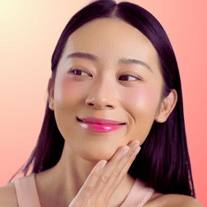 A woman wearing and showcasing the best cruelty-free, vegan, shiny and hydrating lip gloss in shade Candy