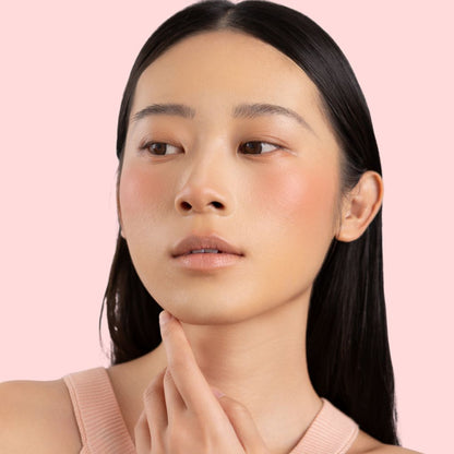 Woman wearing and showcasing the effect of oplenza Velvet Whip cream blush in shade Cloud Peach