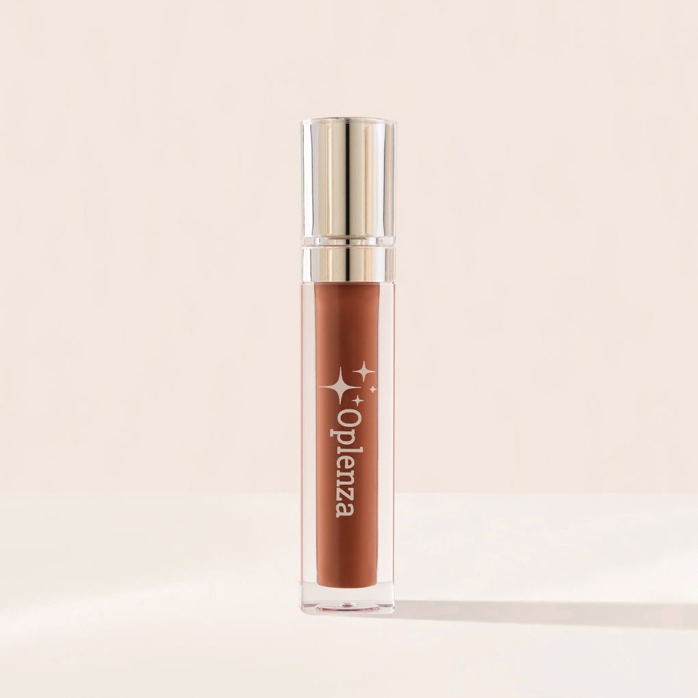 Lip gloss with golden cap and 'Oplenza' branding on a beige background. Cruelty free makeup