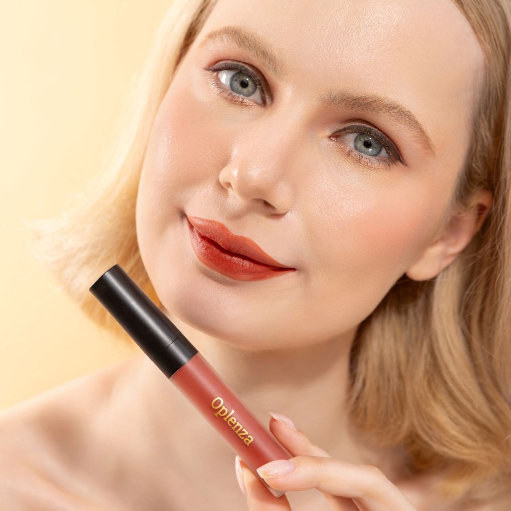 A Woman wearing and showcasing the elegant Oplenza Signature Velvet Liquid Lipstick in the color Crimson Plush