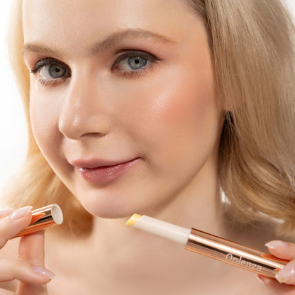 A woman wearing and presenting Oplenza's Hydrating Shimmer Glossy Lip Balm in shade Glassy