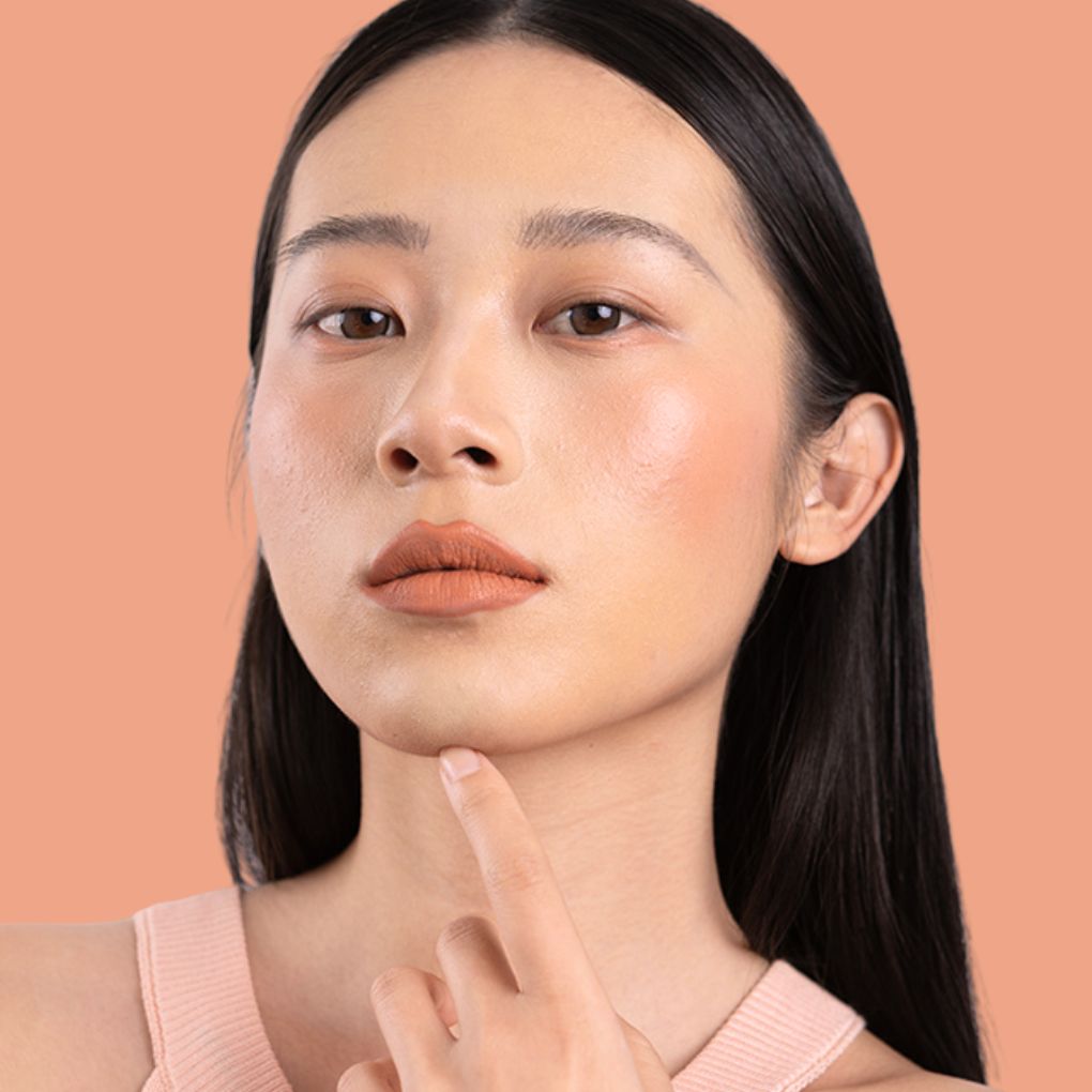 Model wearing and showcasing the bold color of the vegan, cruelty-free Oplenza matte liquid lipstick in the shade Muse