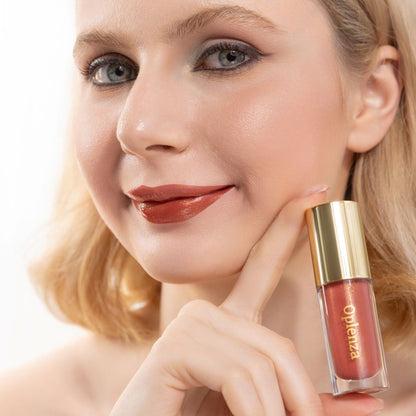 A woman wearing and showcasing the best cruelty-free, vegan, shiny and hydrating lip gloss in shade Rosewood