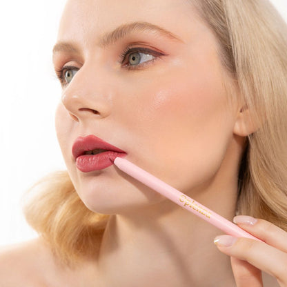 An elegant woman wearing and showcasing the vegan, luxury and cruelty free oplenza Define & Refine Lip Liner in the color Rosy Dusk