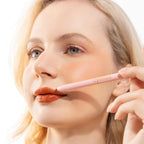 An elegant woman wearing and showcasing the vegan, luxury and cruelty free oplenza Define & Refine Lip Liner in the color 12 Rust Bloom