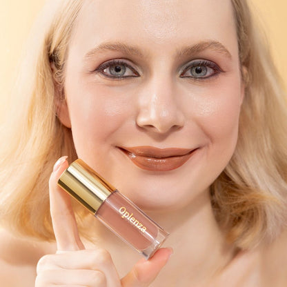 A woman wearing and showcasing the best cruelty-free, vegan, shiny and hydrating lip gloss in shade Silk