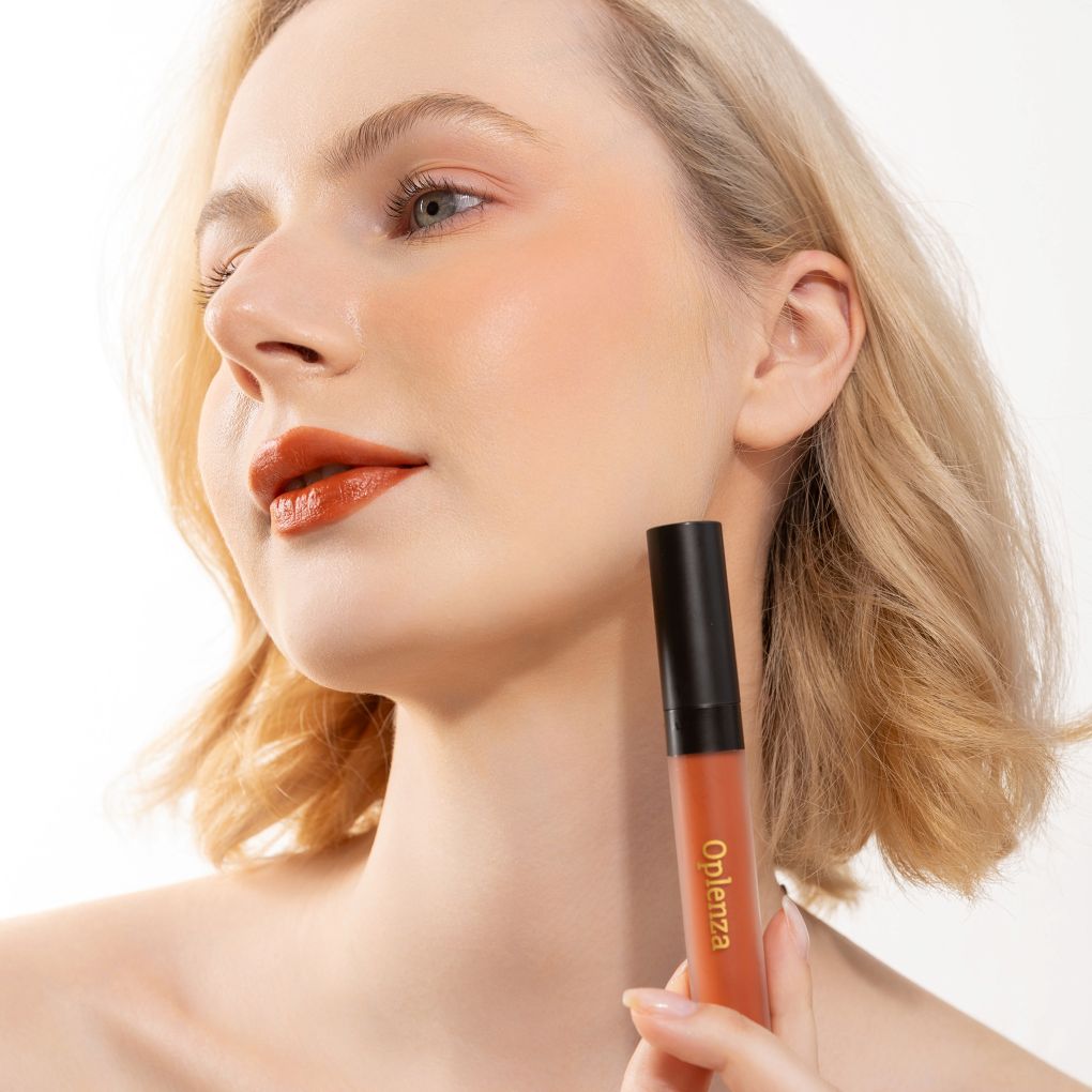 A Woman wearing and showcasing the elegant cruelty free Oplenza Signature Velvet Liquid Lipstick in the color Terracota Luxe